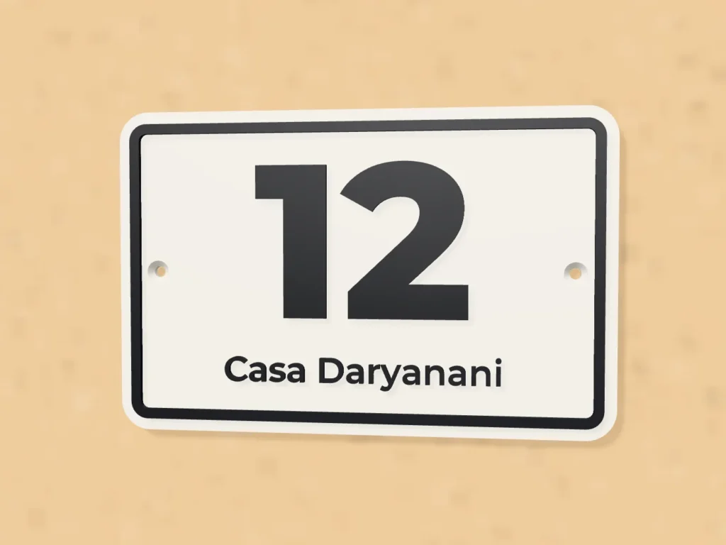 White house number 12 plaque with black border on a wall